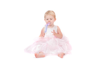 The baby girl in a pink dress on the white background