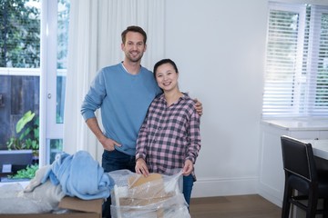 Pregnant couple unpacking boxes in new home