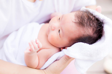 Fototapeta na wymiar Asian newborn in mother's arm after having a bath