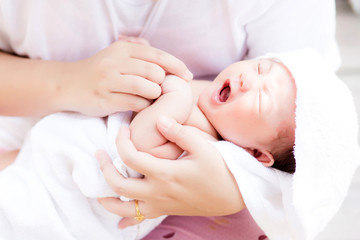 Obraz na płótnie Canvas Asian newborn in mother's arm after having a bath