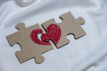 red heart is drawn on pieces of a puzzle lying at a distance