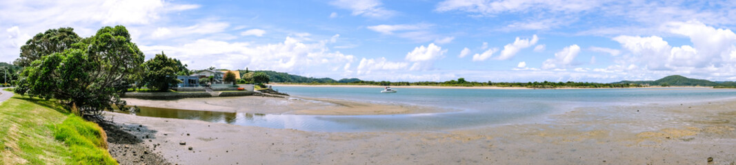 Panorama of Ngunguru Harbour river estuary at low tide - waterfront with anchored motor boat in...