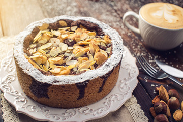 Homemade Christmas or New Year holiday chocolate pie with nuts on wooden table background. Concept of festive desserts