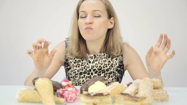 glutton woman eating cupcakes with frenzy after long diet