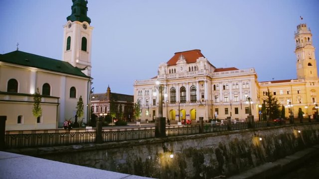 Illuminated City Hall on Oradea embankment in twilight, Romania
