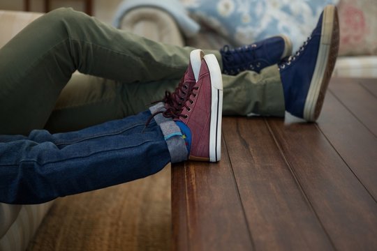 Father And Son Relaxing On Sofa In Living Room