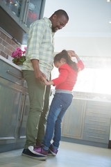 Father and daughter dancing together in kitchen