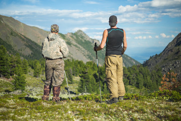 Men hiking in mountains. Siberia.