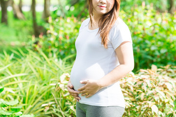 Young Asia pregnant in beautifull garden