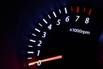 A tachometer gauge inside a car's dashboard