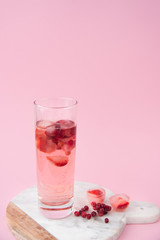A glass of iced tea with frozen strawberry and lingonberry