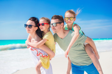 Happy beautiful family of four on beach on vacation