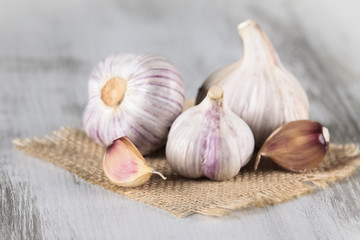 Close-up garlic bulbs and garlic cloves on wooden background