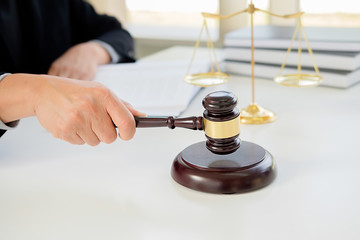 Judge gavel with Justice  lawyers having team meeting at law firm in background. Concepts of law.