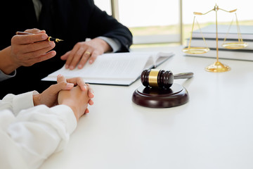 Judge gavel with Justice  lawyers having team meeting at law firm in background. Concepts of law.