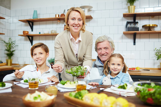 Hospitable grandparents and their grandchildren having breakfast in the kitchen