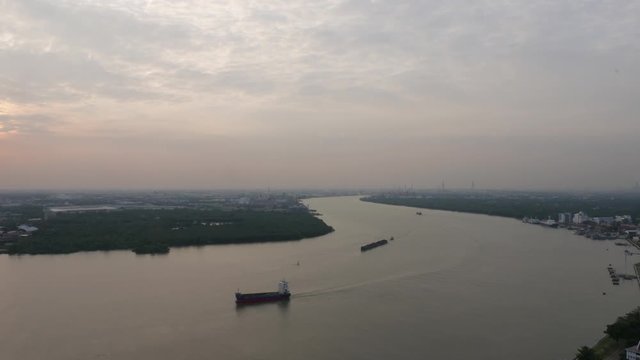 Aerial view of tugboat and Cargo transport ship passing industrial area in Chao Phraya river.  Bangkok, Thailand