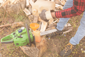 Winter is coming - lumberjack maintaining chainsaw outdoors.