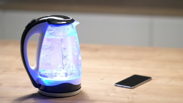 glass electric kettle with lights boils.