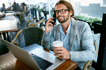 Work From Cafe. Man Talking On Phone Working In Cafe