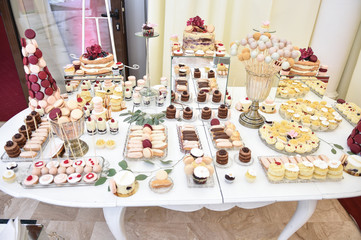 Wedding decoration with pastel colored cupcakes, meringues, muffins and macaroons. Elegant and luxurious event arrangement with colorful macaroons. Wedding dessert with macaroons