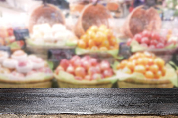 Wood table top on fruit store background.