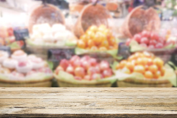 Wood table top on fruit store background.