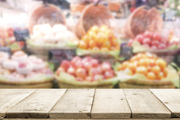 Wood table top on fruit store background.