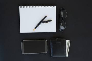 Spectacles, organizer, pen, mobile phone and wallet on