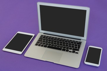 Laptop, mobile phone and digital tablet on purple background