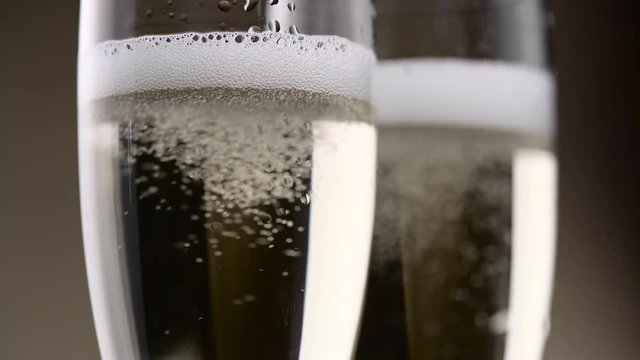 Filled with two glasses of champagne hiss and foam of white bubbles. Close up