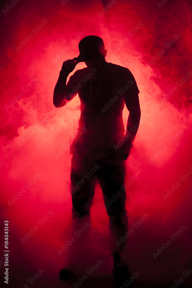 Wall mural silhouette of a man in fog red light