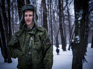 happy young soldier portrait in the winter forest