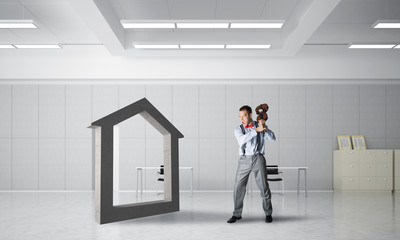 Fototapeta premium Stone home silhouette as symbol for real estate insurance crashed by man