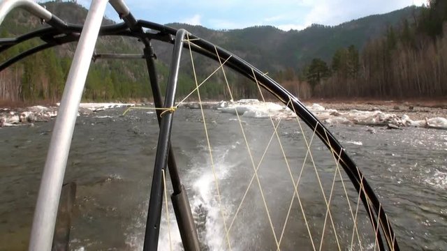 Airboat airglider on mountain river Temnik. Clean water and stone rock bottom in spring. Border of Baikal State Nature Biosphere Reserve. Ecotourism in Siberia of Russia.