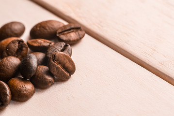 Coffee beans on wooden table close up macro. Place for text.