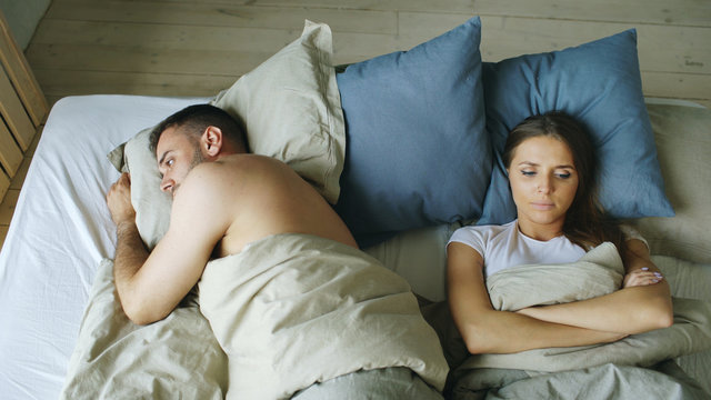 Top View Of Upset Lying Sleepless Couple In Bed Offended Because Of Quarrel