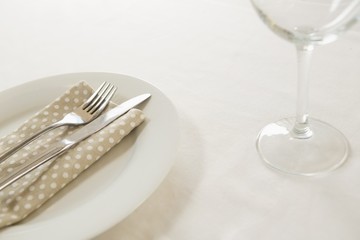 Fork and butter knife with napkin arranged in a plate