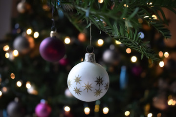Merry christmas tree decoration gold star and pink ball with blurry bokeh light background