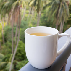 White cup of Chinese green tea on the windowsill