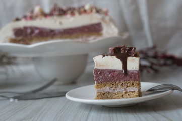 Gentle Muscovy cake with raspberry curd and poppy cakes, decorated with strawberries, chocolate, marshmallows and frosting on a light wooden background