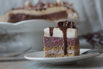 Gentle Muscovy cake with raspberry curd and poppy cakes, decorated with strawberries, chocolate, marshmallows and frosting on a light wooden background