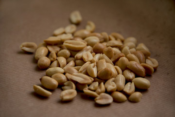 Roasted, salted peanuts on brown paper