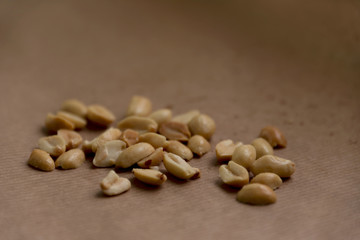 Roasted, salted peanuts on brown paper