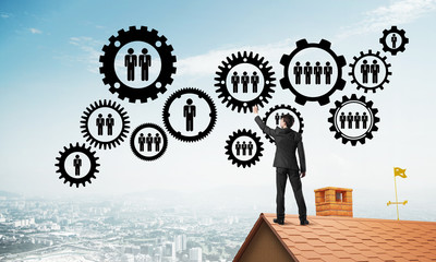 Businessman on house roof presenting teamwork and connection concept. Mixed media