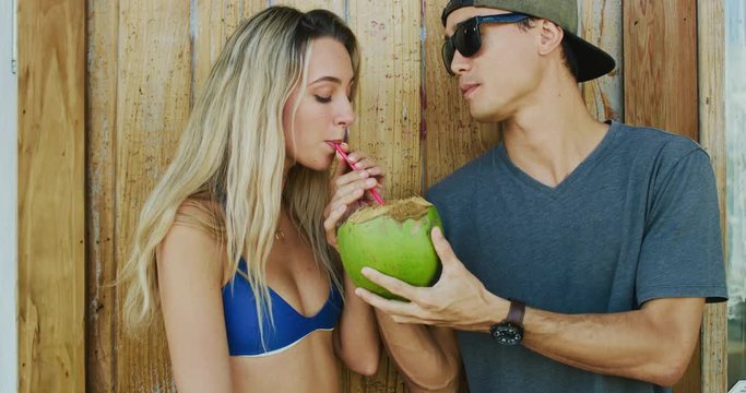Travel lifestyle concept, young couple hanging out enjoying coconut and skateboarding around beach town