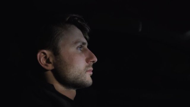 Profile of man's face while driving a car on the highway