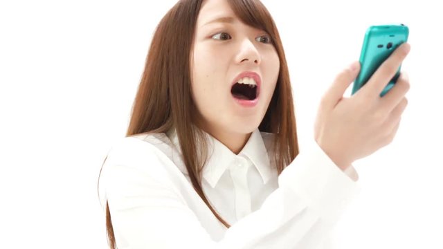 スマホを見て驚く女性