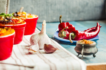 Garlic and red fresh hot pepper in sticks on a blue plate. Portioned casserole. Eastern.cuisine spice.