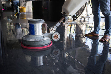 The people cleaning floor with machine.